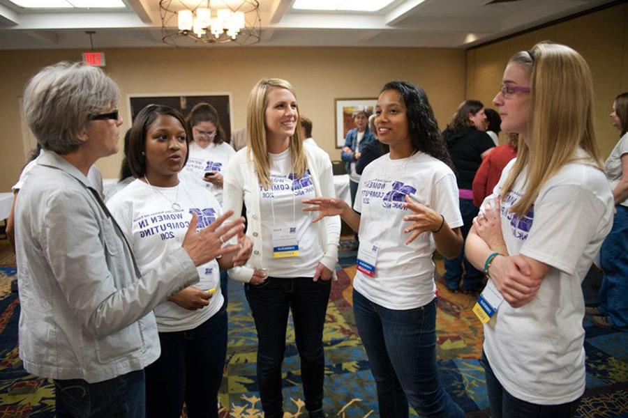 Dr. 卡罗尔Spradling, right, converses with women at the biannual Missouri Iowa Nebraska Kansas Women in Computing Conference, 是她共同创立的.